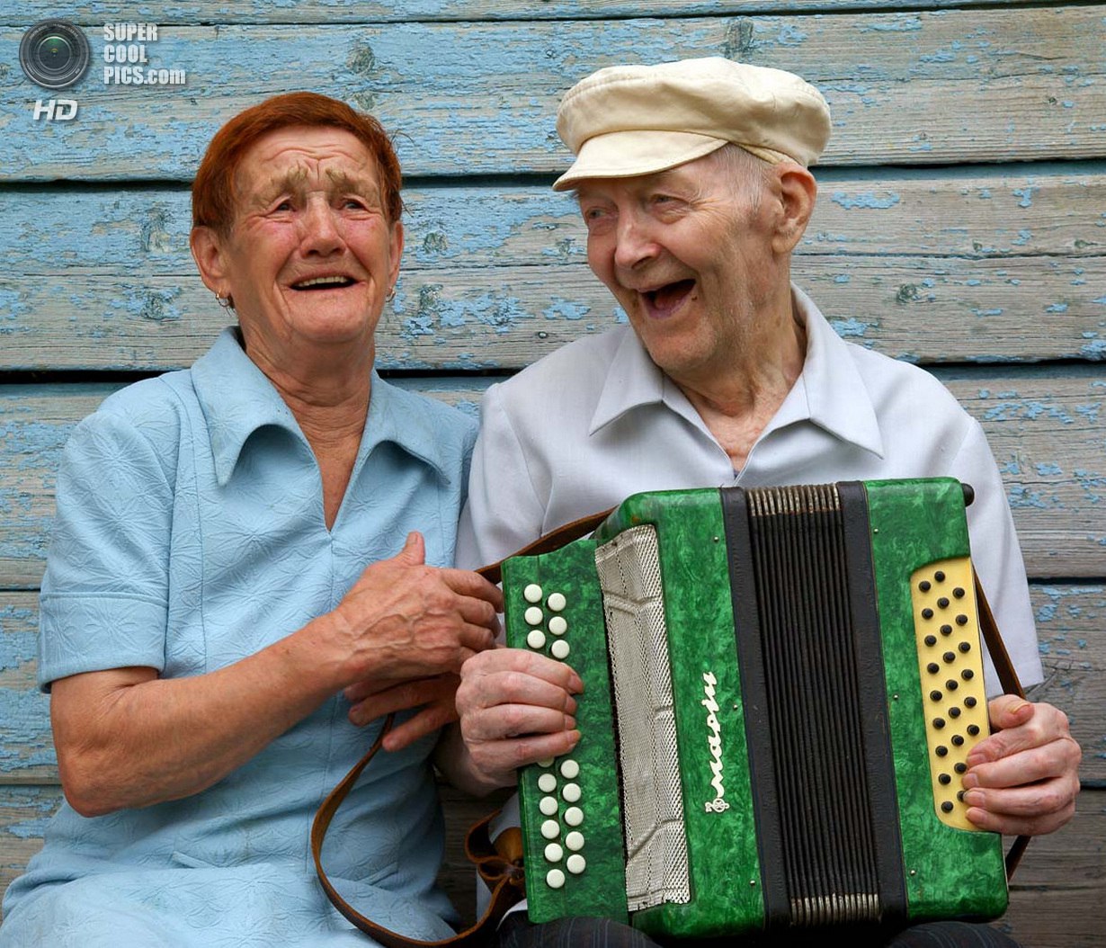Поет песни под гармонь. Дедушка с баяном. Дед с гармошкой. Бабушка и дедушка поют.