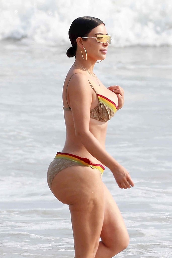 Ким Кардашян с несравненной сублимацией тела, распылающейся на пляже под теплыми солнечными лучами