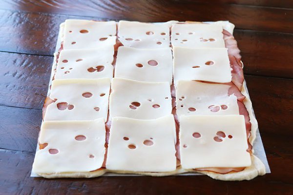 Закуска с ветчиной и сыром.Вам понадобятся: 1 упаковка слоеного теста 300 г ветчины 12 ломтиков ... - 6